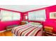 Vibrant bedroom with hardwood floors, two windows, and a striped bedspread at 701 Rosedale Se Dr, Smyrna, GA 30082