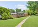 Back of the home shows a well-manicured lawn and garden, with brick accents and a large deck at 701 Rosedale Se Dr, Smyrna, GA 30082
