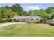 Well-maintained ranch home with a large, green front lawn and mature trees at 701 Rosedale Se Dr, Smyrna, GA 30082