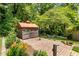 Close-up of a gazebo in a garden setting with a brick patio and beautiful plantings at 701 Rosedale Se Dr, Smyrna, GA 30082