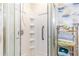 Walk-in shower with built-in shelving, glass door, and a silver towel rack with plush, colorful towels at 701 Rosedale Se Dr, Smyrna, GA 30082