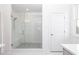 Modern bathroom featuring a frameless glass shower with a bench and white tiled walls at 816 Dodd S Trl # 172, Buford, GA 30518
