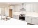 This kitchen features a large island, gas range, stainless hood, and white cabinets at 816 Dodd S Trl # 172, Buford, GA 30518