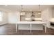 Open concept kitchen with large center island, stainless appliances, and modern light fixtures at 816 Dodd S Trl # 172, Buford, GA 30518