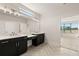 Bathroom featuring double vanities, modern fixtures, large mirror, and view to the outside at 1619 Tielman Way, Snellville, GA 30078
