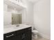 Modern bathroom with dark vanity, white countertop, large mirror and a toilet at 1619 Tielman Way, Snellville, GA 30078