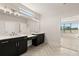 Contemporary bathroom with dual sinks, quartz countertops, and a view of the backyard at 1619 Tielman Way, Snellville, GA 30078