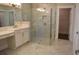 Bathroom featuring a glass shower, dual sinks, and vanity with cabinets at 1619 Tielman Way, Snellville, GA 30078