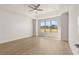 Spacious bedroom featuring a tray ceiling, a large window overlooking a yard and wood-look flooring at 1619 Tielman Way, Snellville, GA 30078