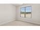 Bright bedroom with neutral carpet and walls, and a large window overlooking the yard at 1619 Tielman Way, Snellville, GA 30078