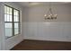 Dining room with dark hardwood floors, wainscoting, and a modern chandelier at 1619 Tielman Way, Snellville, GA 30078