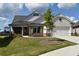 Charming home with stone accents, a manicured lawn, and a welcoming front porch at 1619 Tielman Way, Snellville, GA 30078