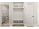 Hallway featuring a built-in storage bench, with an opening to a laundry room with gray cabinets at 1619 Tielman Way, Snellville, GA 30078