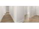Bright hallway featuring wood-look floors, crisp white trim, and multiple doorways leading to various rooms at 1619 Tielman Way, Snellville, GA 30078