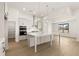 Modern kitchen with white cabinetry, stainless steel appliances, large island, and wood flooring at 1619 Tielman Way, Snellville, GA 30078