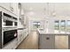 Open kitchen with large island, stainless appliances, white cabinets, and pendant lighting at 1619 Tielman Way, Snellville, GA 30078