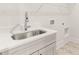 Close up of laundry room featuring stainless sink and gray cabinets with neutral walls and floor at 1619 Tielman Way, Snellville, GA 30078