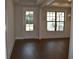 Bright room featuring hardwood floors, a glass-paneled door, and large windows at 1619 Tielman Way, Snellville, GA 30078