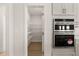 Well-organized walk-in pantry with wire shelving for ample storage, next to double oven at 1619 Tielman Way, Snellville, GA 30078