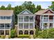 Charming three-story home featuring a double porch, gray siding, and beautiful landscaping at 2059 Wheaton Way, Atlanta, GA 30328