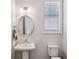 Charming powder room with a pedestal sink, an oval mirror and a window at 2059 Wheaton Way, Atlanta, GA 30328