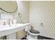 Bathroom with pedestal sink, wallpapered accent wall and black trim around the toilet at 2983 Crosswycke Forest Dr, Brookhaven, GA 30319