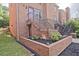 Brick townhouse featuring tidy landscaping with decorative rocks, black mulch, and lush green grass at 87 Davis Mill Ct, Lawrenceville, GA 30044
