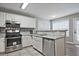 Well-equipped kitchen featuring stainless steel appliances, white cabinets, and a breakfast bar, seamlessly blending style at 87 Davis Mill Ct, Lawrenceville, GA 30044
