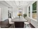 Dining room featuring a long table, white chairs, coffered ceiling and a modern chandelier at 1158 Welch Sw St, Atlanta, GA 30310