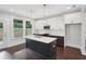 Kitchen with stainless appliances, white cabinets, dark wood floors, and quartz countertops and backsplash at 1158 Welch Sw St, Atlanta, GA 30310