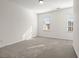 Bright bedroom with neutral carpet, white walls, and natural light from two windows at 310 Rose Garden Ln, Alpharetta, GA 30009