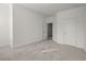 Well-lit bedroom features plush carpeting, white walls, and convenient access to a nearby hallway at 310 Rose Garden Ln, Alpharetta, GA 30009