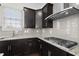 Close up of modern kitchen with granite countertops, stainless steel appliances, and tile backsplash at 310 Rose Garden Ln, Alpharetta, GA 30009
