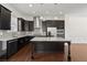 Modern kitchen featuring dark cabinetry, stainless steel appliances, and a granite island at 310 Rose Garden Ln, Alpharetta, GA 30009