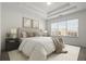 A bright main bedroom features a tray ceiling, neutral decor, and a large window offering neighborhood views at 310 Rose Garden Ln, Alpharetta, GA 30009