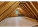 Unfinished attic space showing the bare wood construction with a small window at the far end at 3175 Lake Seminole Pl, Buford, GA 30519