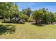 Beautifully landscaped backyard with mature trees providing ample shade on a sunny day at 3175 Lake Seminole Pl, Buford, GA 30519