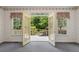 Exterior view of landscaped backyard with a deck, garden, and lush greenery visible through open doors at 3175 Lake Seminole Pl, Buford, GA 30519