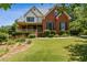 Charming two-story brick home with a welcoming front porch and lush, landscaped front yard at 3175 Lake Seminole Pl, Buford, GA 30519