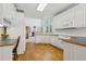 Open concept kitchen with white cabinetry, hardwood floors, and adjacent fireplace at 3175 Lake Seminole Pl, Buford, GA 30519