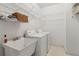 Practical laundry room with utility sink, washer, dryer, wire shelving, and tile flooring at 3175 Lake Seminole Pl, Buford, GA 30519