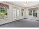 Sunroom with gray carpet, scenic wallpaper, and a glass patio door leading to a backyard view at 3175 Lake Seminole Pl, Buford, GA 30519