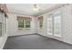 Bright sunroom with gray carpet, white trim, multiple windows, and a glass patio door leading to the outdoors at 3175 Lake Seminole Pl, Buford, GA 30519