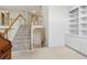 Bright staircase with carpet runner leads to upper level, complemented by built-in shelving at 3175 Lake Seminole Pl, Buford, GA 30519