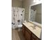 This bathroom includes vanity with mirror and tub shower combo with decorative curtain at 407 Aerif Place Pl, Woodstock, GA 30188