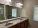 Bathroom featuring double vanity with granite counters, decorative mirrors, and tiled floors at 407 Aerif Place Pl, Woodstock, GA 30188