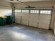 Spacious garage with white door including window inserts, as well as two garbage bins at 407 Aerif Place Pl, Woodstock, GA 30188