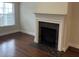 Cozy living room featuring a decorative fireplace, hardwood floors, and natural light at 407 Aerif Place Pl, Woodstock, GA 30188