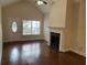 Bright living room with fireplace, hardwood floors, and a vaulted ceiling at 407 Aerif Place Pl, Woodstock, GA 30188