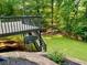 Backyard view of upper deck and stairs down to level yard with wooded backdrop at 1801 Summerview Ct, Woodstock, GA 30189